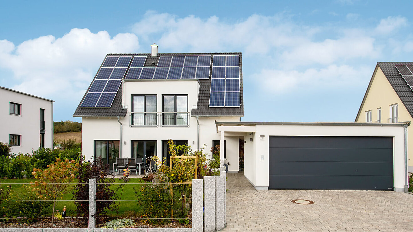 Ressourcenhaus von Aischtaler Holzhaus mit Photovoltaikanlage und moderner Garage